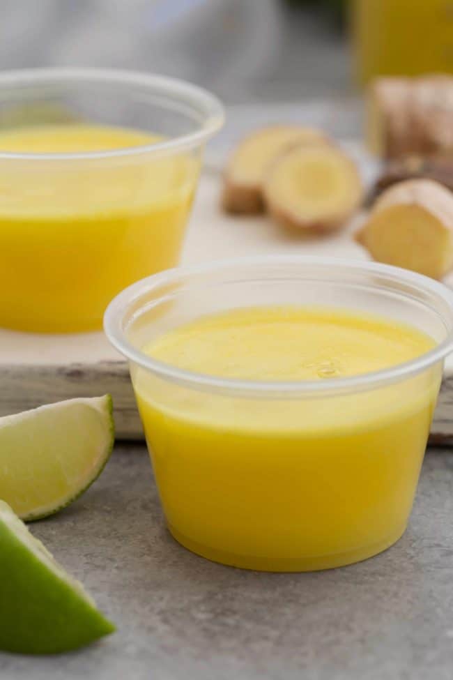 Small plastic container filled with pineapple drinks.