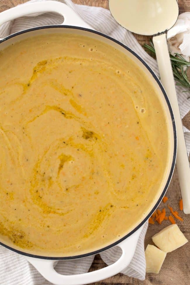 A white pot filled with creamy soup.