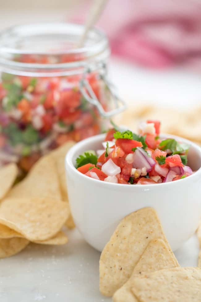 A small white bowl filled with fresh salsa fresca.