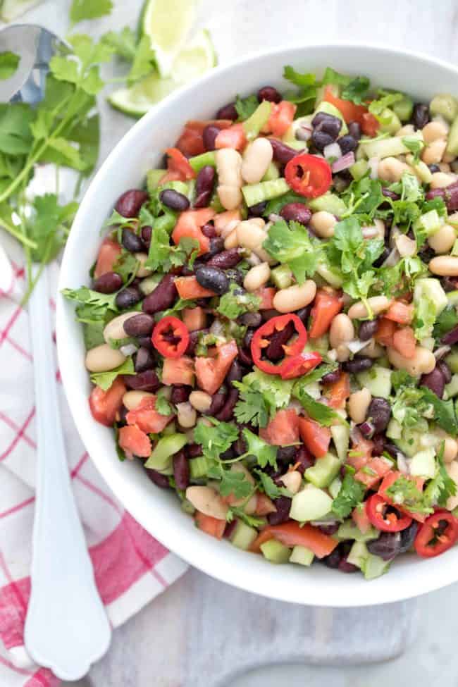 A white bowl filled with Mexican Bean Salad.