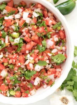 A white bowl filled with Pico de Gallo (salsa fresca)