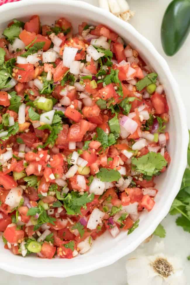 A white bowl filled with homemade Pico de Gallo (Mexican salsa fresca).