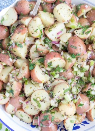 A white bowl filled with red skin potato salad