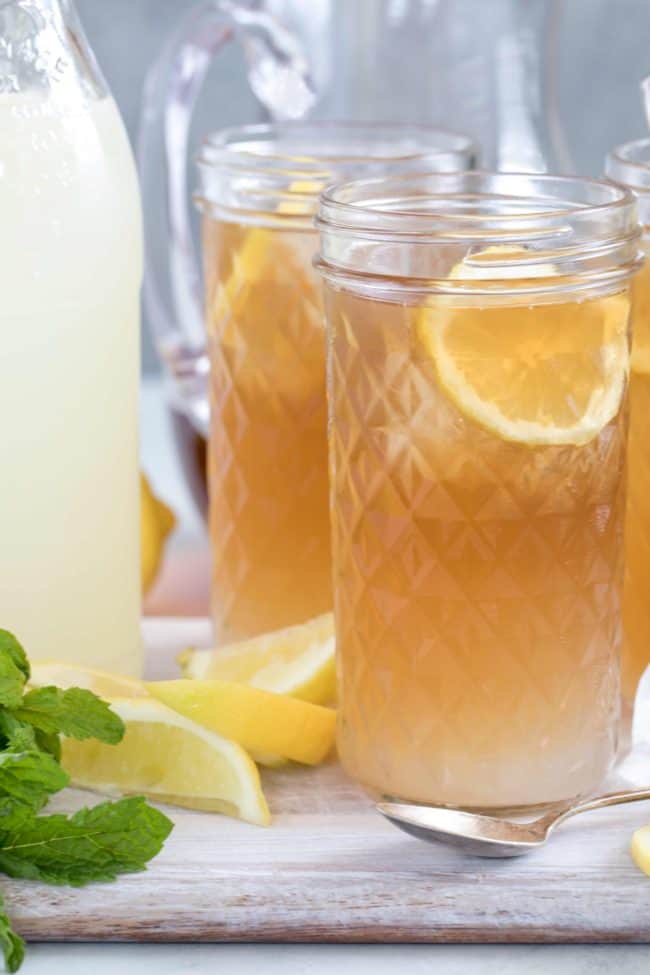 Two clear drinking glasses filled with Arnold Palmer Drink (iced tea lemonade).