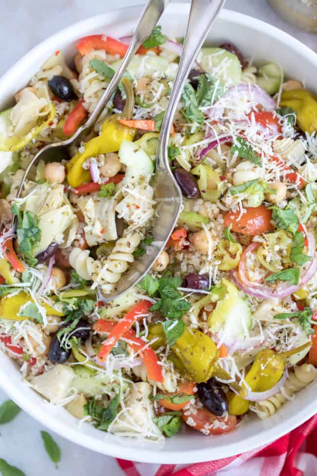 A white bowl of tossed noodle salad.