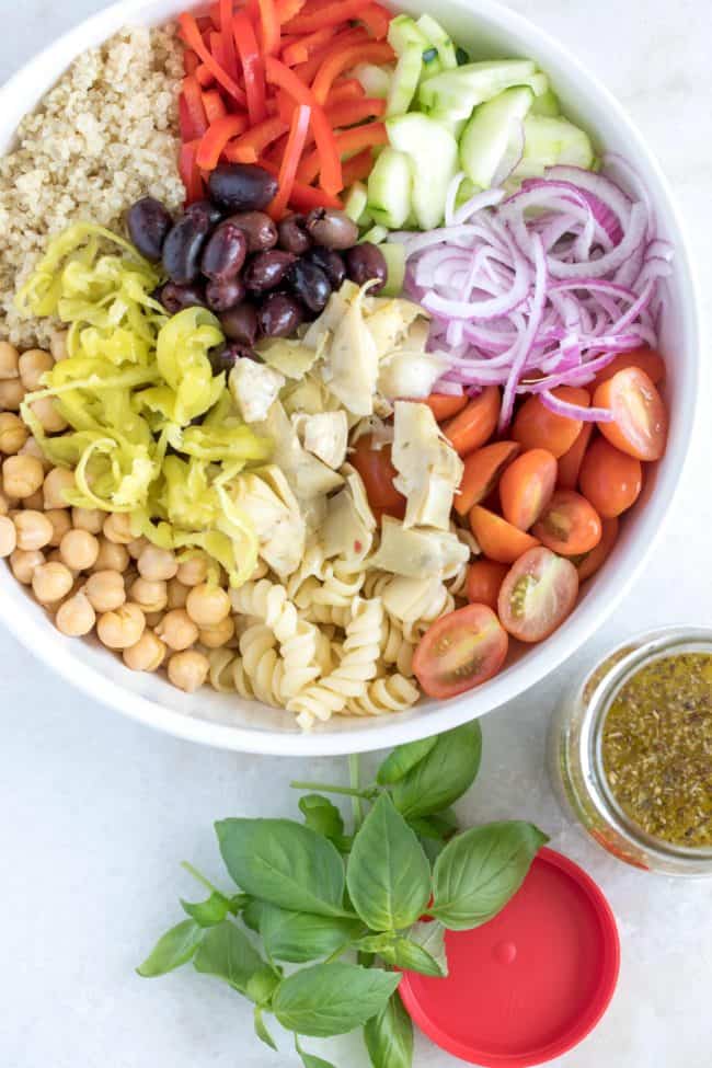 A white bowl of chickpeas, vegetables and quinoa.