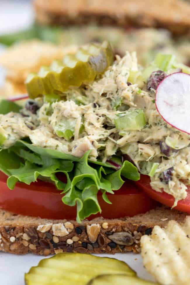 A healthy tuna salad sandwich with tomatoes and lettuce.