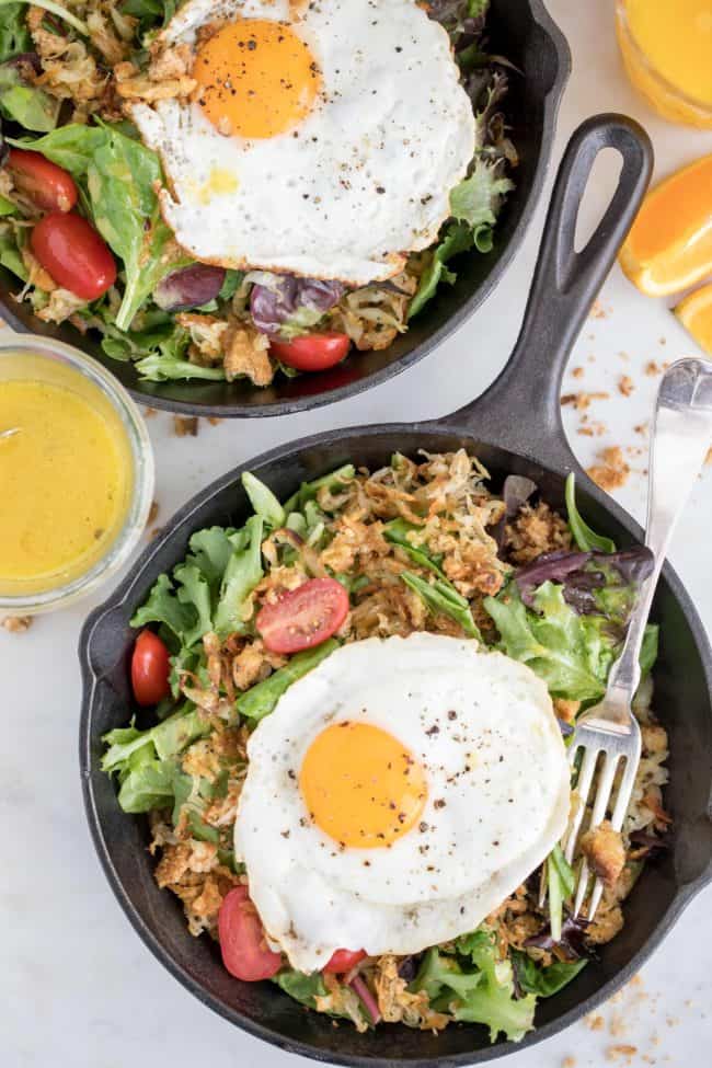 bowl of greens with sunny side up eggs