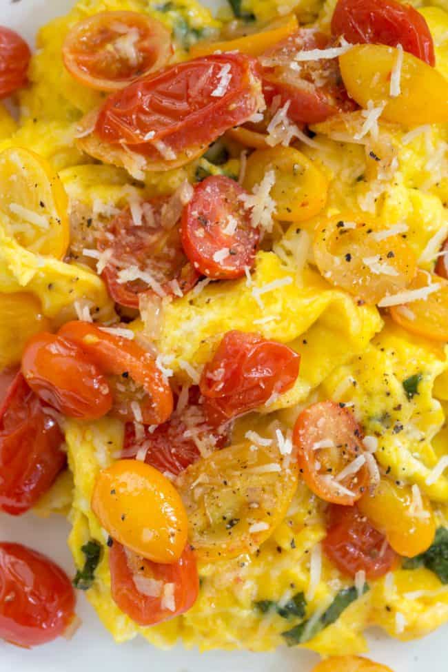 These Tomato Basil Scrambled Eggs make a delicious protein rich breakfast made with eggs, fresh basil, pan-roasted cherry tomatoes and parmesan cheese