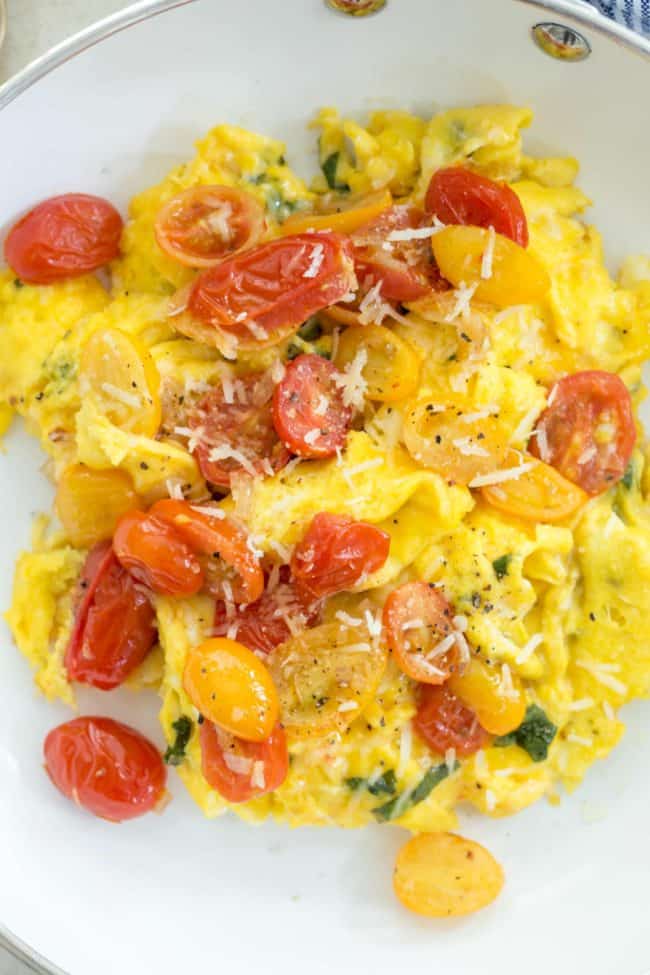 These Tomato Basil Scrambled Eggs make a delicious protein rich breakfast made with eggs, fresh basil, pan-roasted cherry tomatoes and parmesan cheese