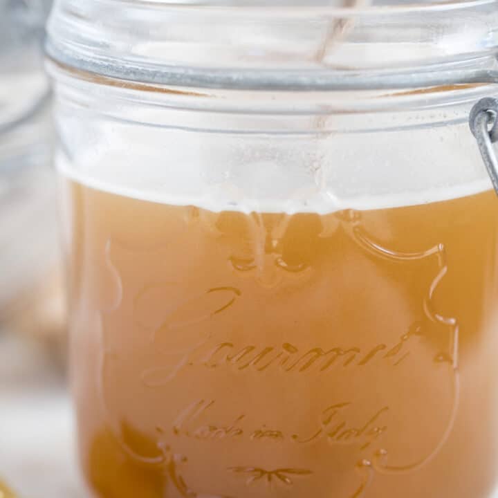 A clear mason jar filled with ginger syrup.