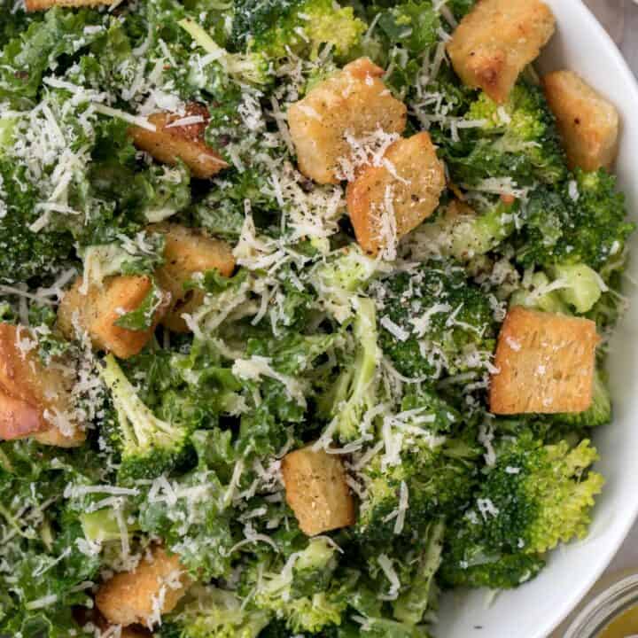 A white bowl filled with broccoli and kale salad.