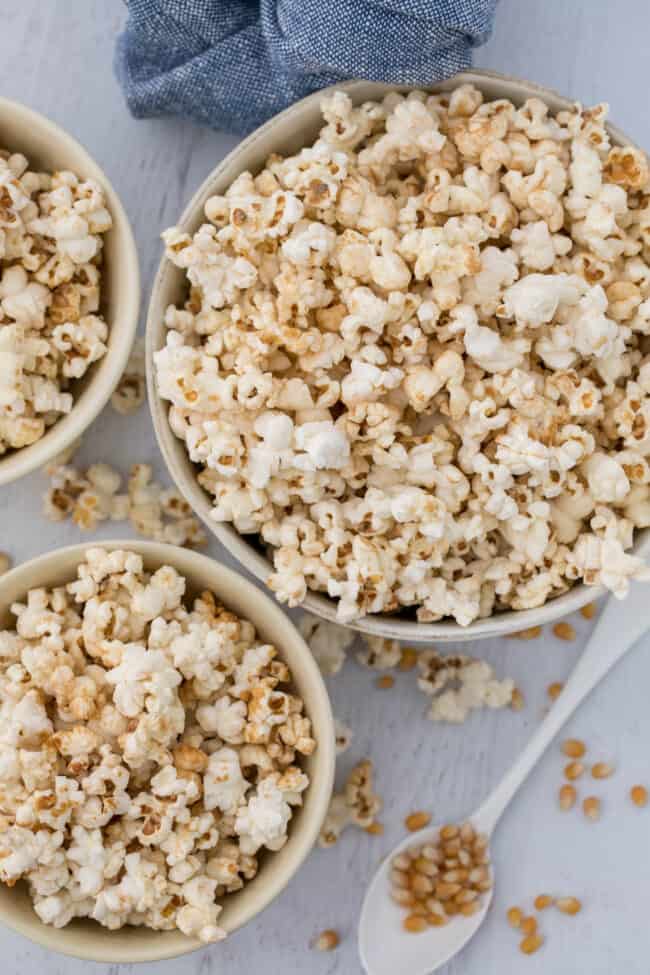 Three white bowls of homemade kettle corn (sweet and salty popcorn).