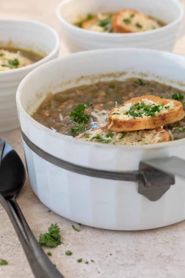 A white pot filled with French lentil soup.