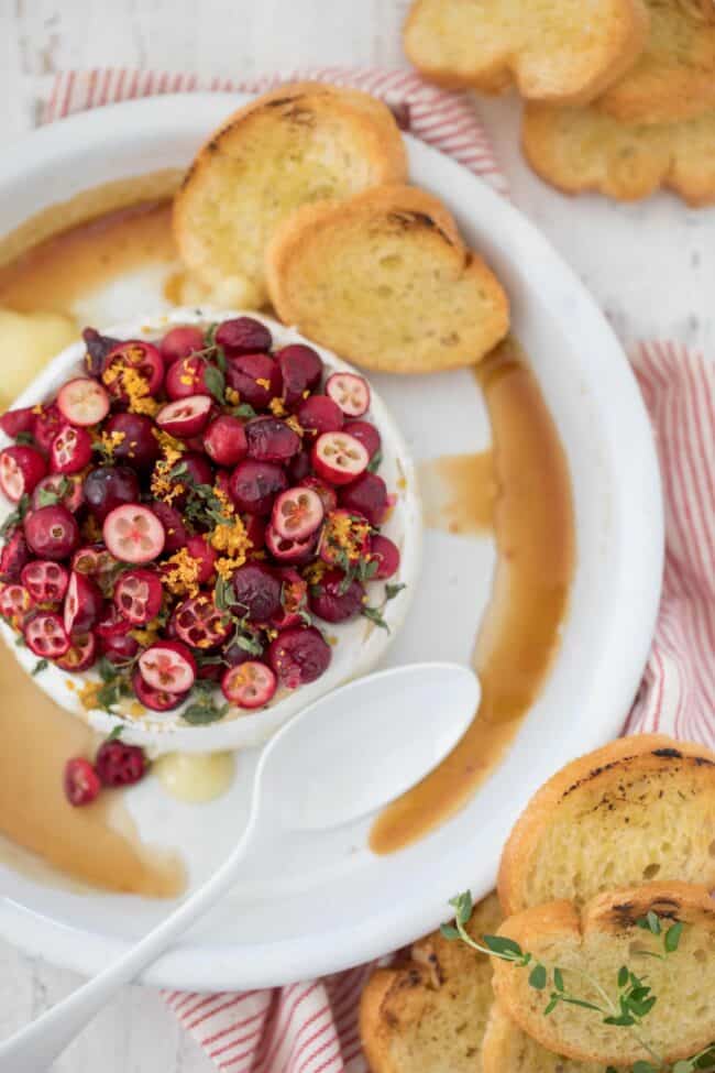 A cranberry and cheese appetizer with pieces of toast.