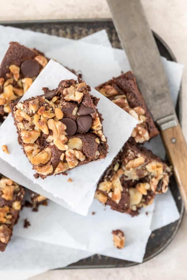 Baking tray filled with fudgy brownies . A knife sits next to them on the tray.