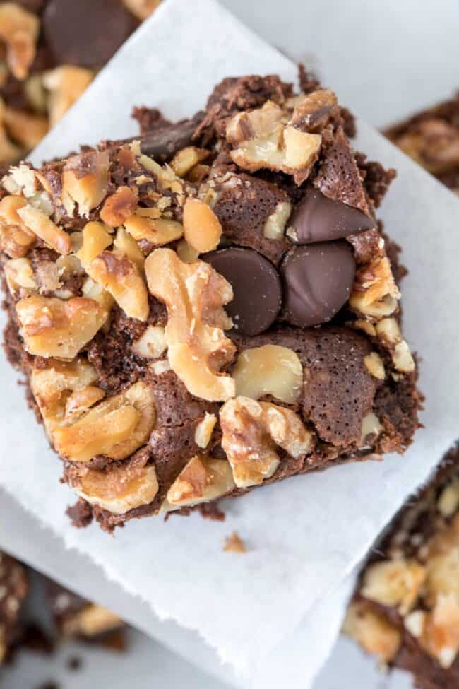 chocolate brownie with walnuts on white parchment paper