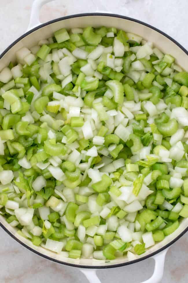 White pot with chopped onions and celery to make vegan stuffing