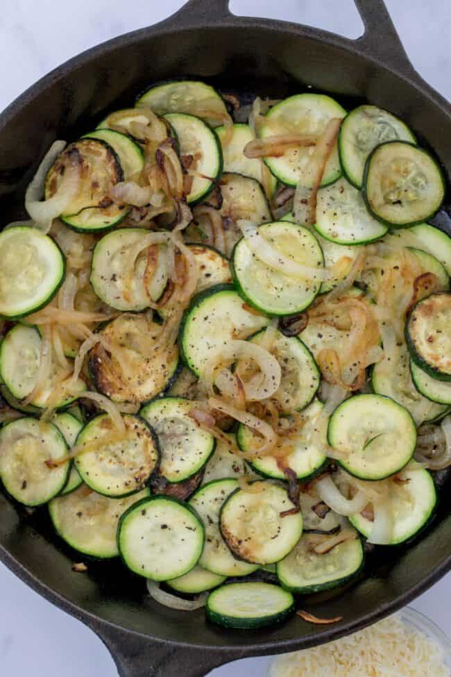 A cast iron skilled filled with cooked vegetables. 