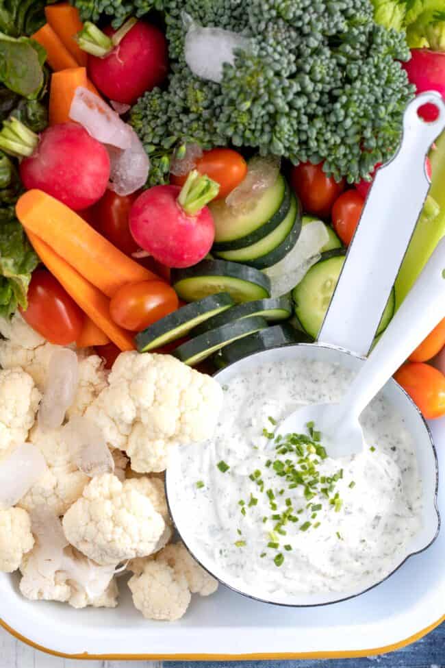 A white tray filled with vegetables and a bowl of homemade Greek yogurt ranch dip.