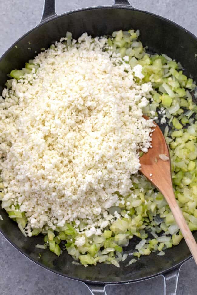 A skillet filled with cooked onion and celery.