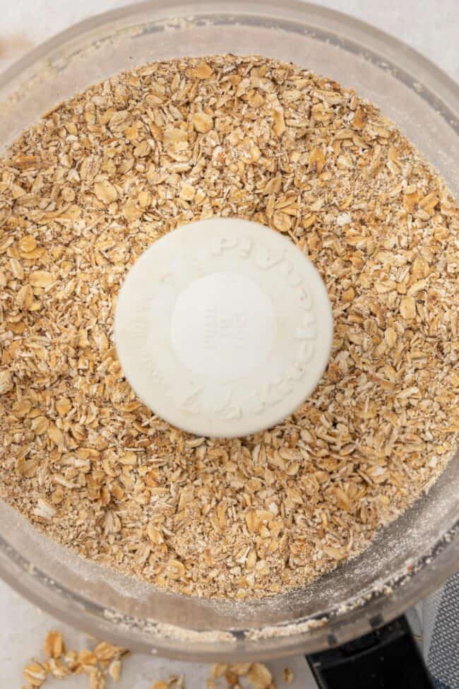 A food processor filled with rolled oats to make homemade instant oatmeal.