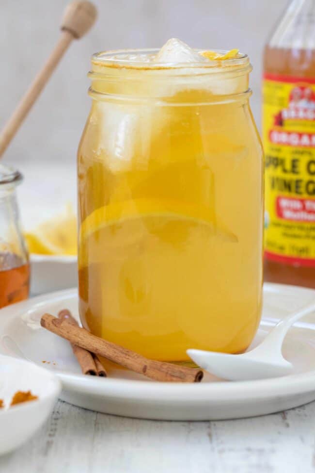 A clear glass jar of apple cider vinegar drink made with Bragg ACV