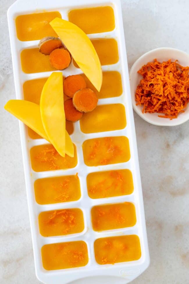 White trays filled with frozen fruit. 