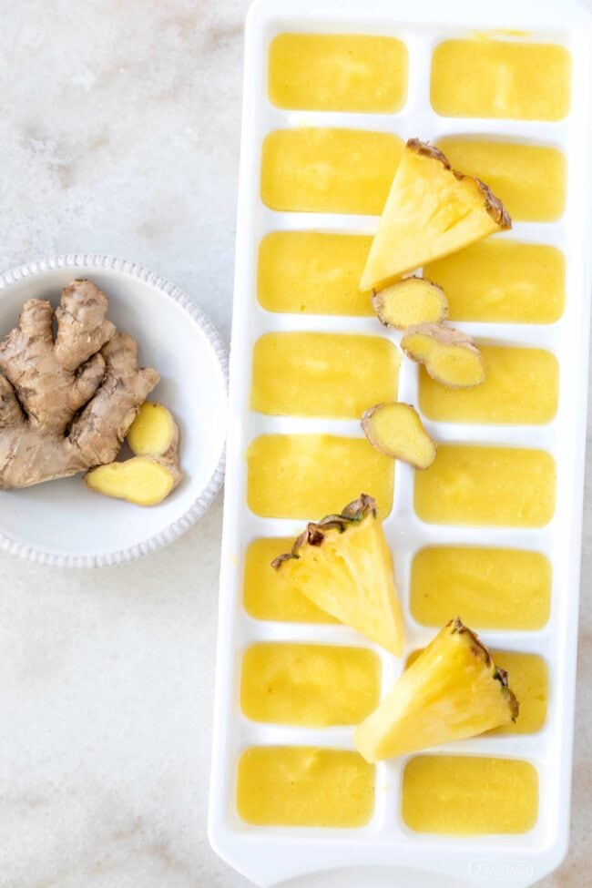 A white tray filled with pineapple smoothie cubes.