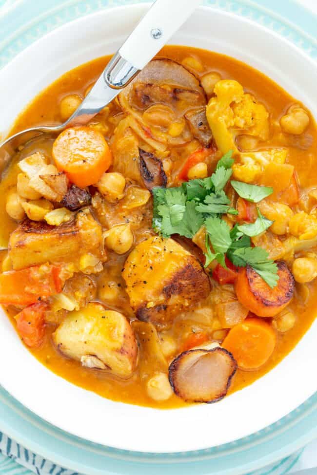 A white bowl filled with cooked vegetables in broth.