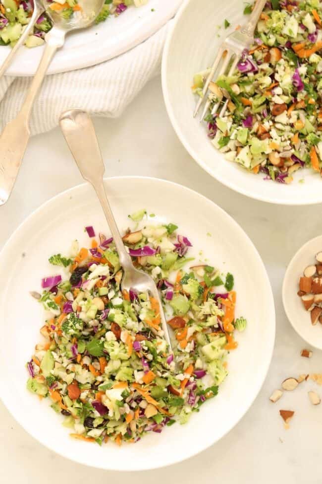 Three white plates filled with finely chopped vegetables.