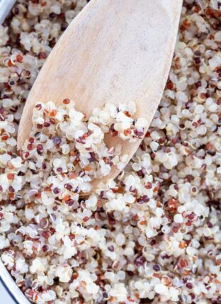 A white pot filled with cooked quinoa.