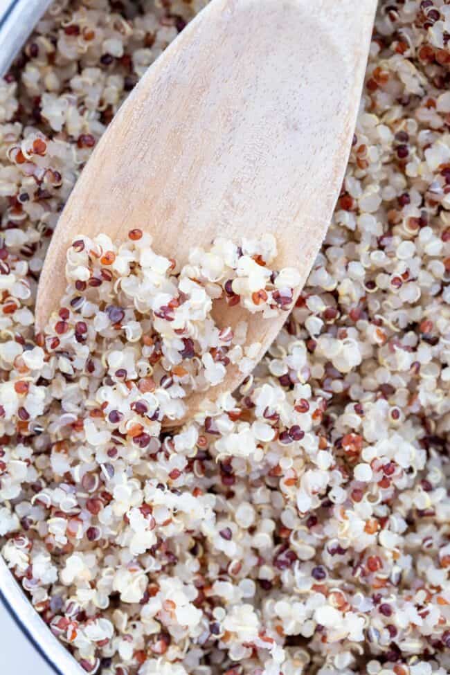 A white pot filled with cooked quinoa.