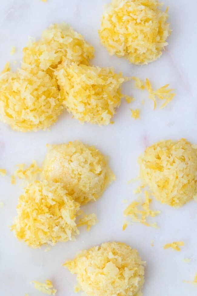 Piles of citrus rind on a white cutting board.