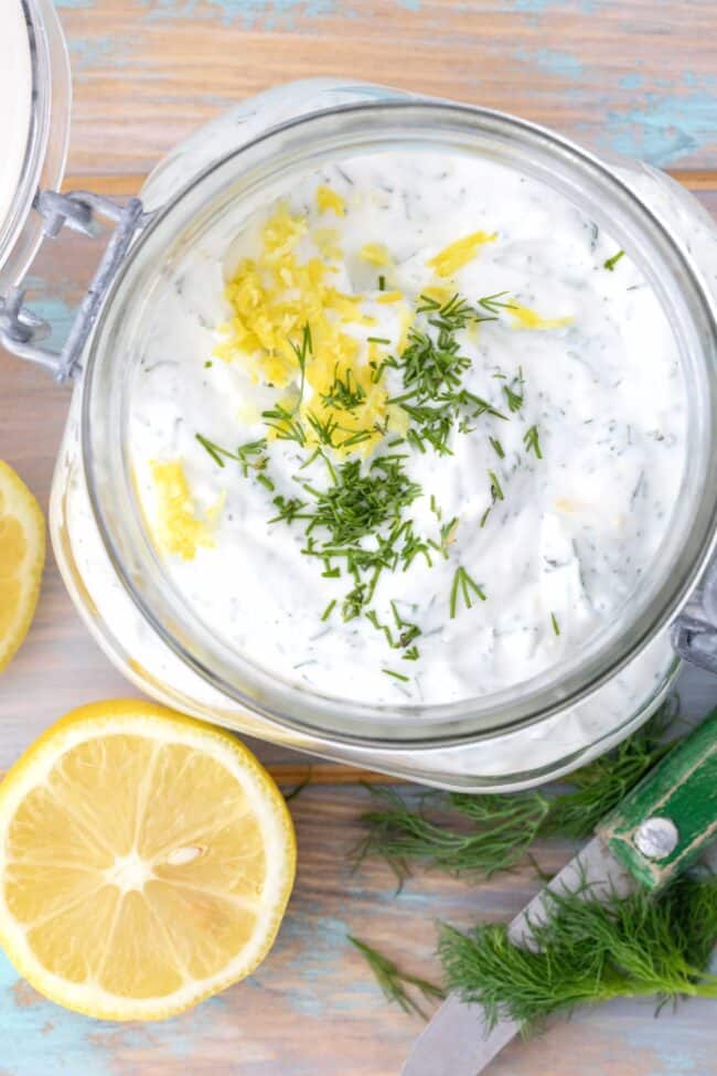 A clear mason jar filled with yogurt dill sauce.