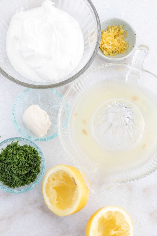 Clear glass bowls filled with citrus juice, fresh herbs and mayonnaise.