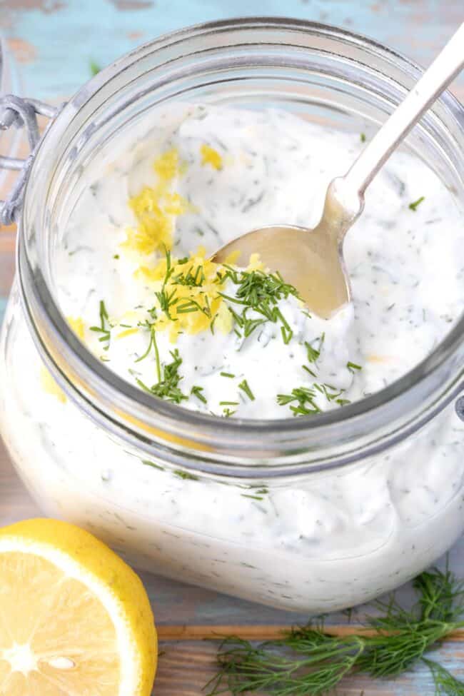 A clear mason jar filled with tzatziki type dip.