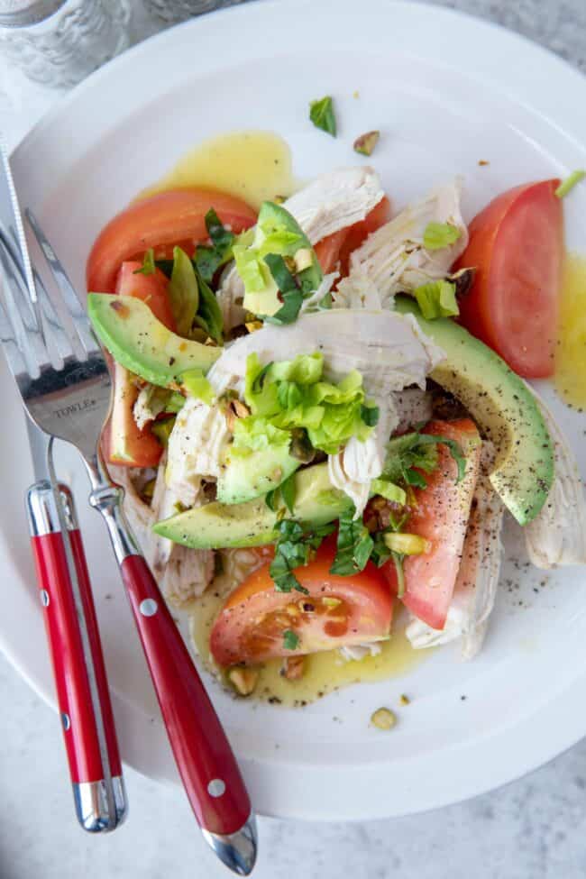 A white plate of shredded chicken and vegetables.