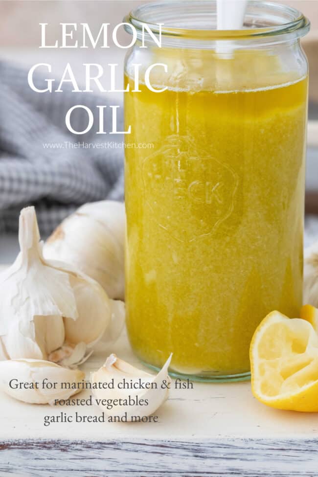 A clear glass jar filled with garlic infused olive oil.