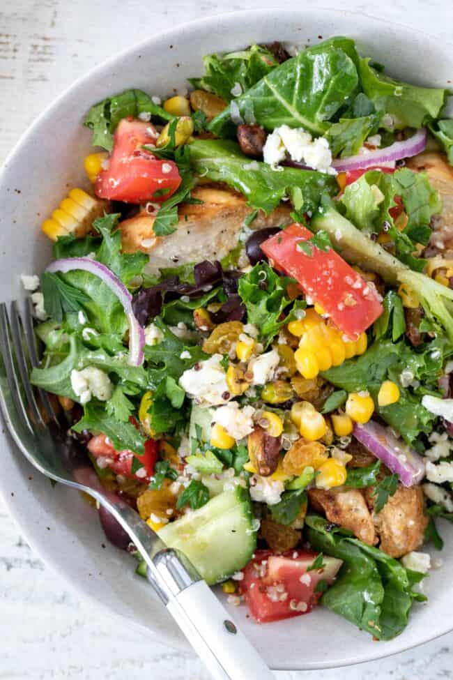 A bowl of mixed greens tossed with vegetables.
