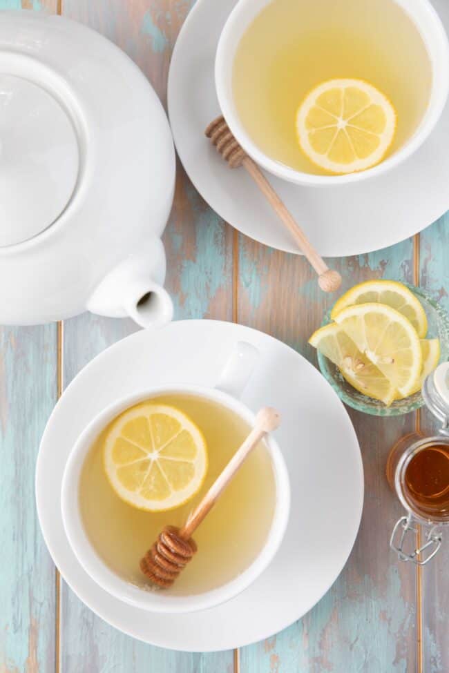 Two white cups of lemon and ginger tea.