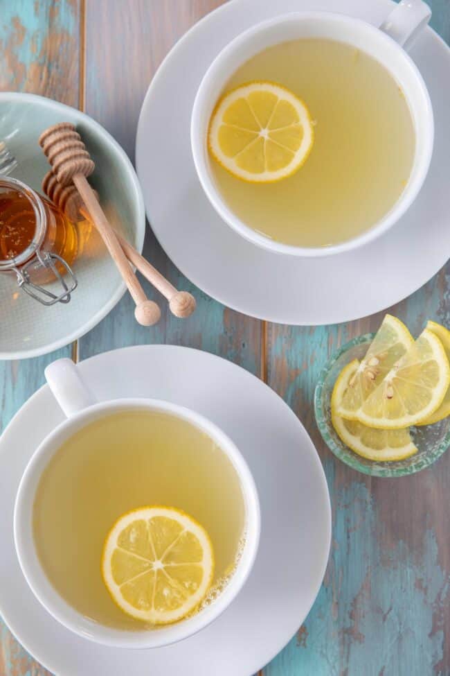 Two white cups of lemon and ginger tea.