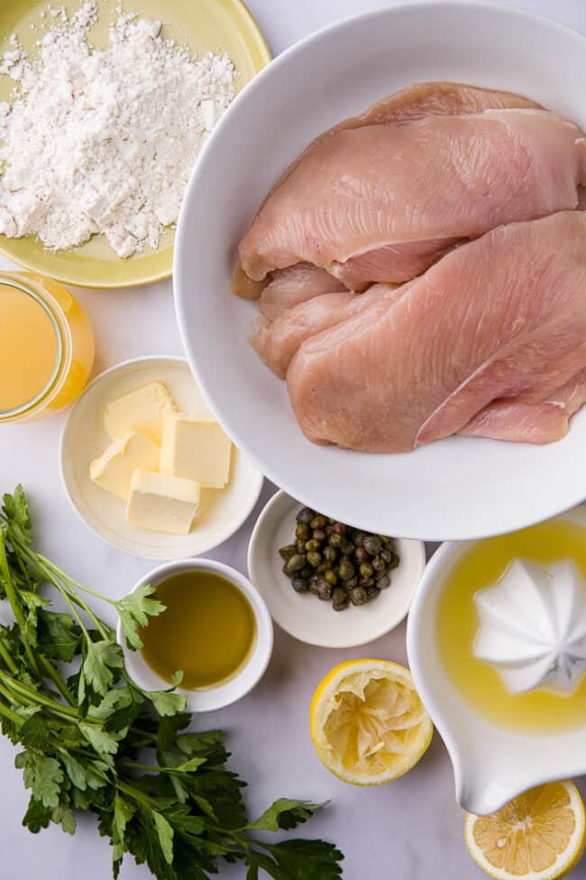 White measuring bowls of ingredients for chicken piccata recipe.