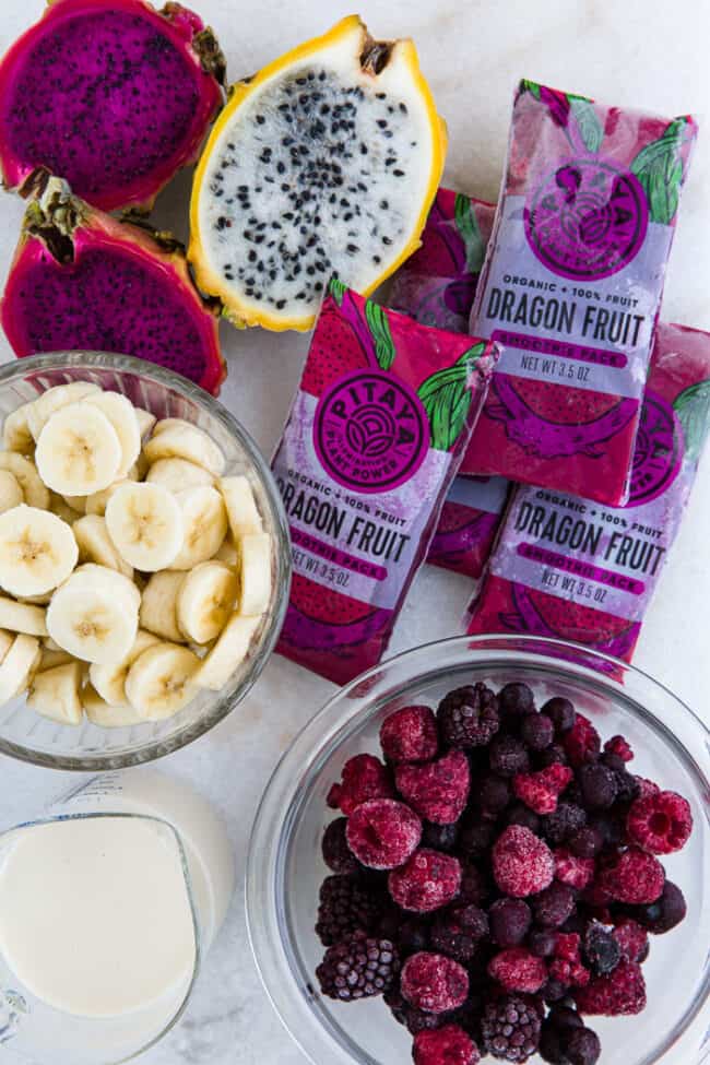 Two clear glass bowls with frozen banana and berries.