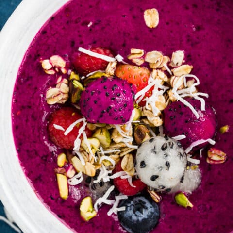 A white bowl of red dragon fruit pitaya smoothie.