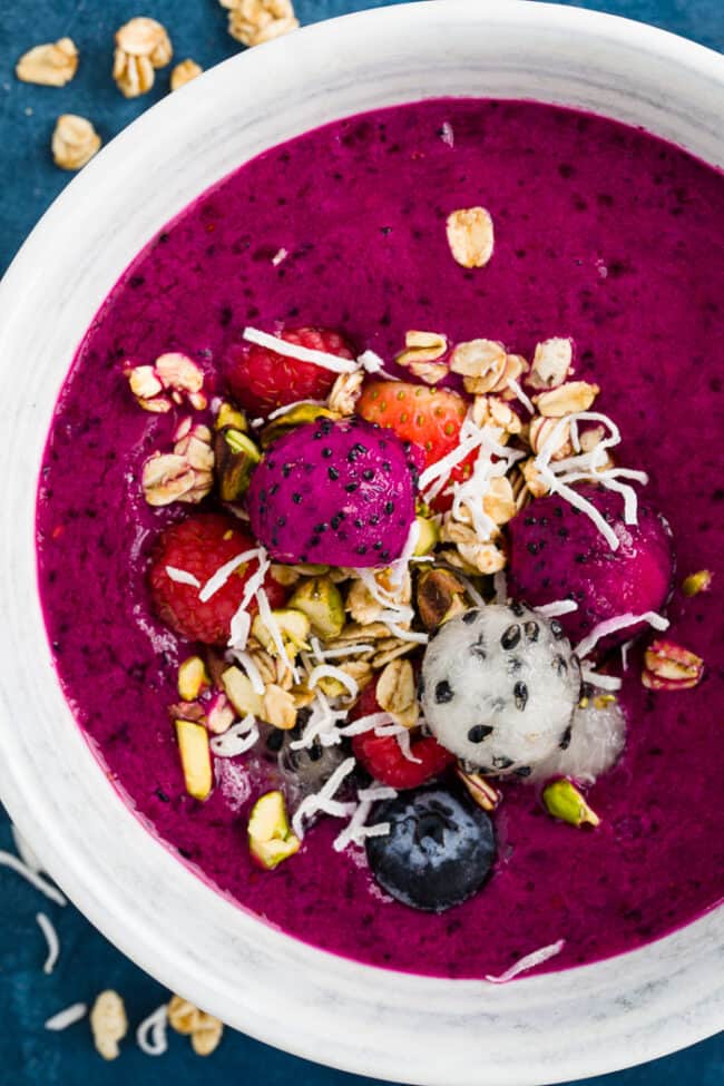 A white bowl with dragon fruit smoothie for dragon fruit smoothie bowl recipe.