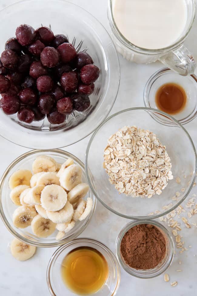 Glass mixing bowls filled with cherries, banana slices, cinnamon and vanilla 