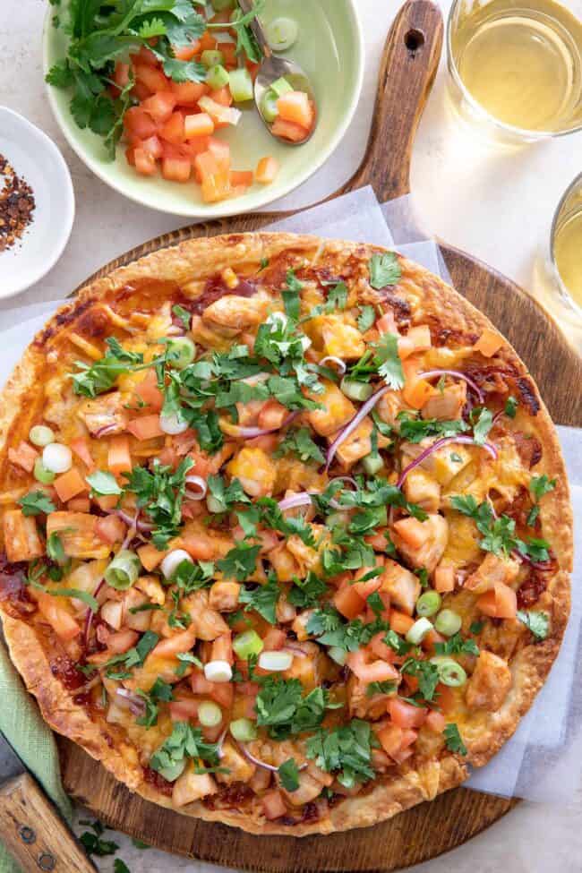 Chicken and cheese flat bread on a wooden board.