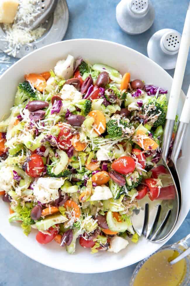 A white bowl of tossed broccoli cauliflower salad.