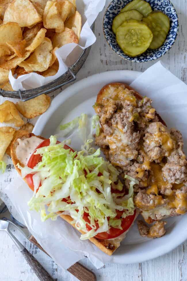  white plate with ground turkey, bread and basket of potato chips